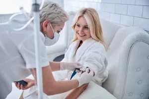 phlebotomist starting an iv on a woman for iv therapy 