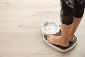 woman standing on a scale weighing herself