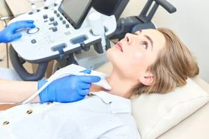 woman getting ultrasound to check thyroid gland