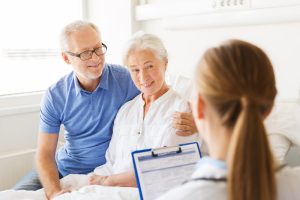 man and woman talking to doctor