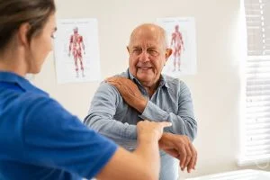 chiropractor helping older male patient