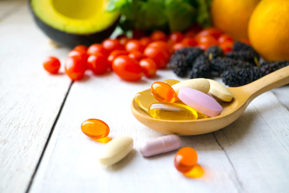 vitamins with vegetables and fruit in the background